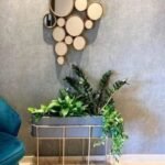 Un pot ovale sur un élégant support accueille une variété de plantes vertes